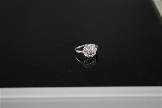A white metal and eleven stone diamond circular cluster ring, size K, gross weight 3.1 grams.